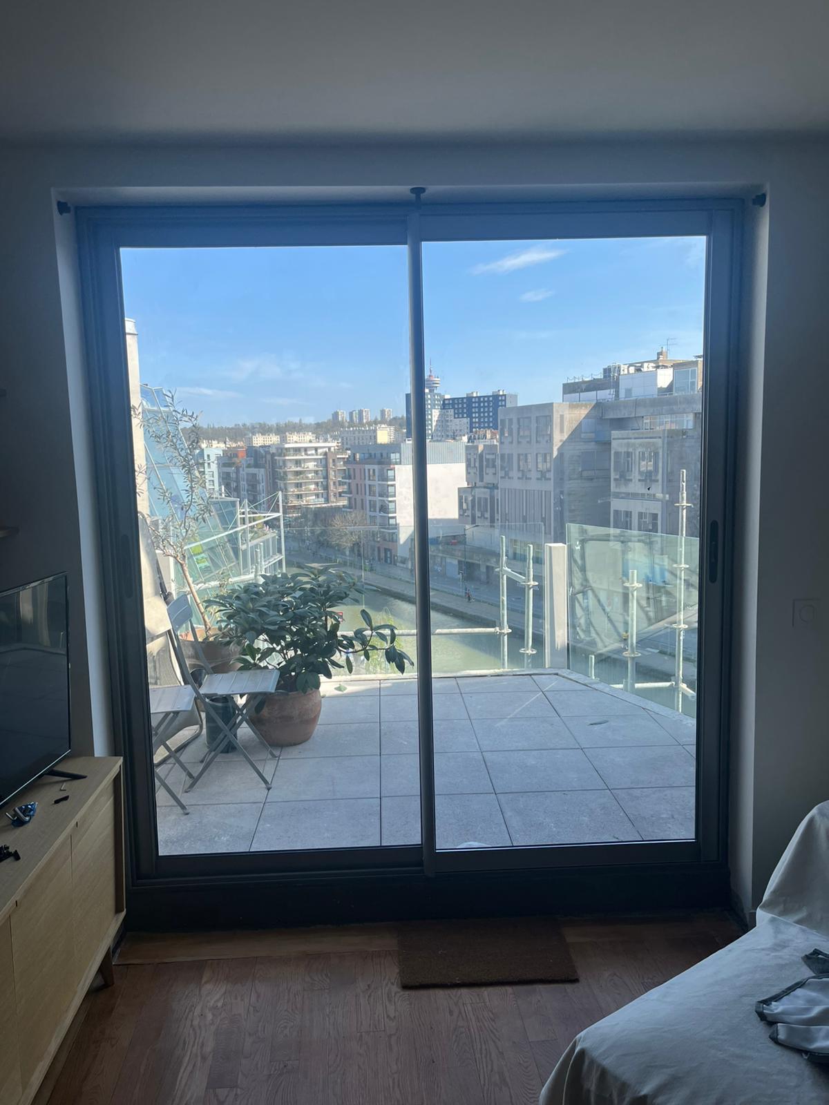 Fenêtre coulissante en aluminium noir avec grande baie vitrée offrant une vue panoramique